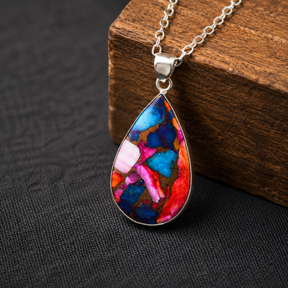 Close-up of pear shaped copper turquoise pendant showing blue, pink and orange composite stone detail