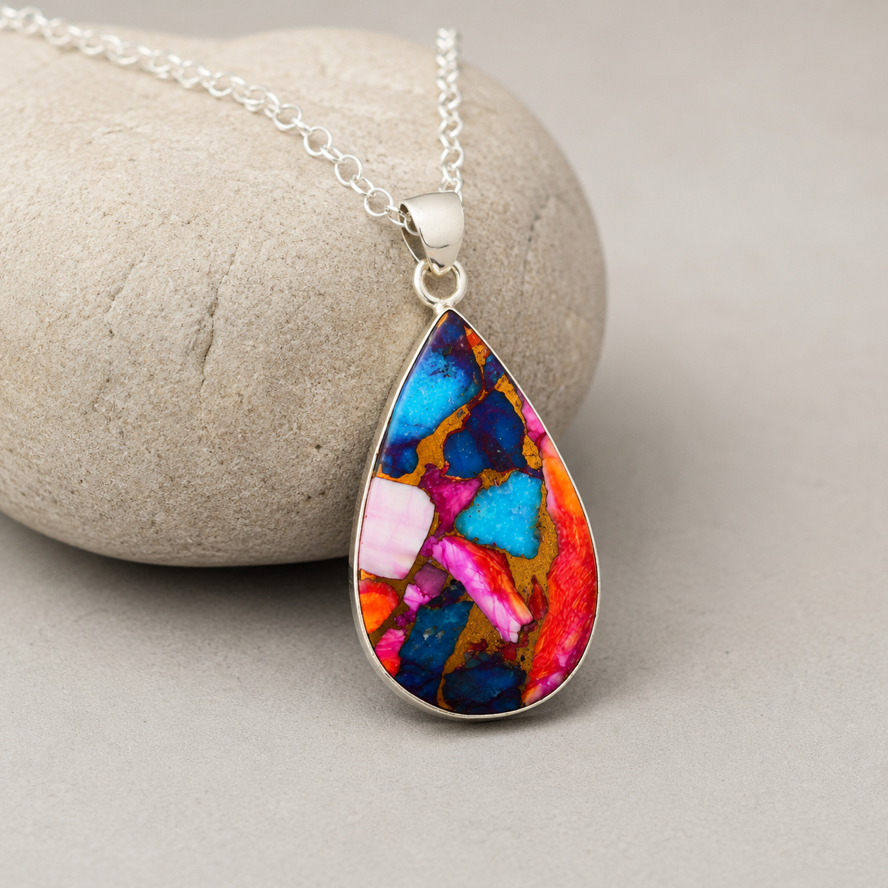 Copper turquoise and spiny oyster pear pendant necklace styled on wooden display block