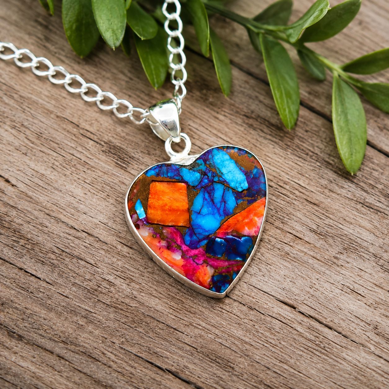 Close-up of heart shaped copper turquoise pendant showing blue and orange composite stone detail
