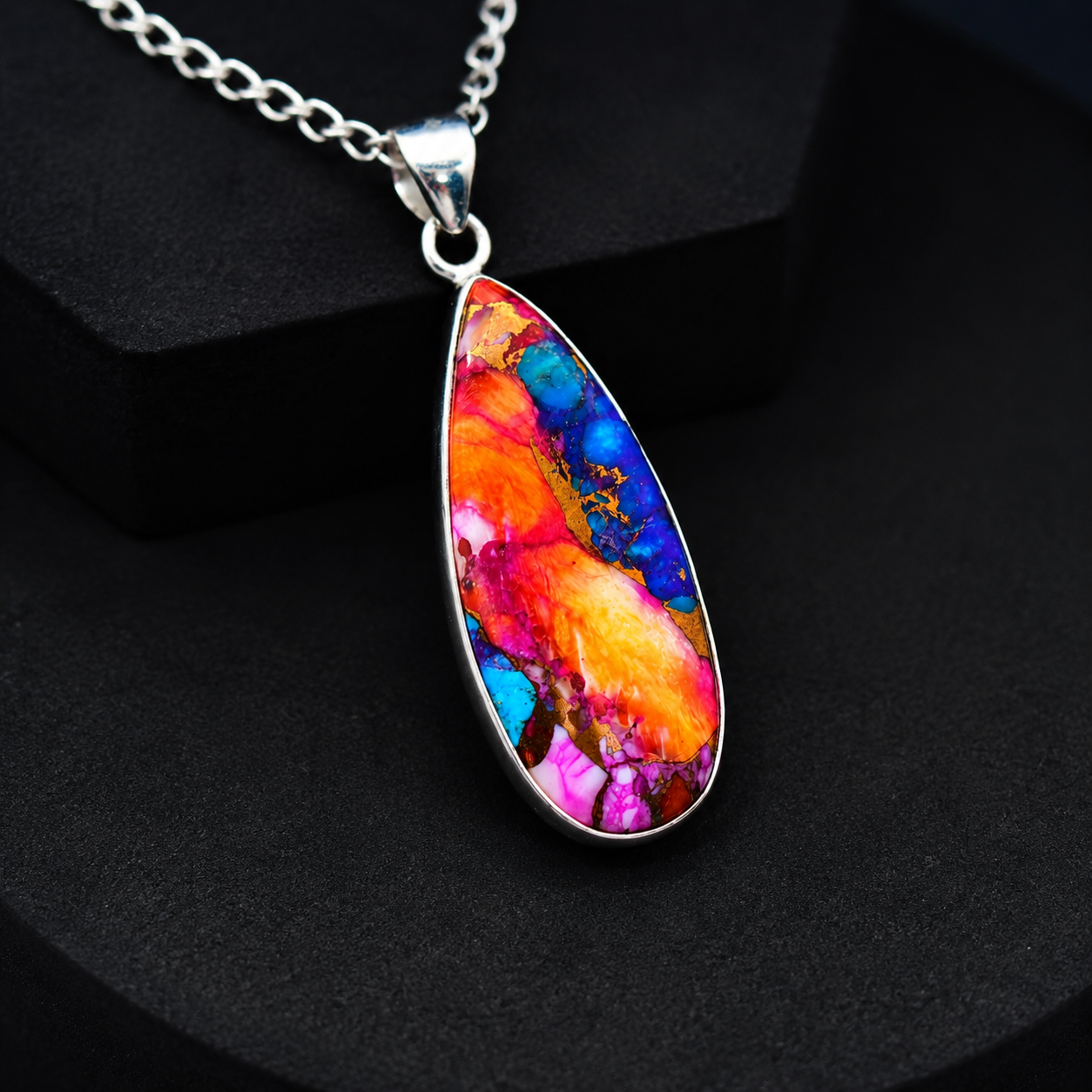 Copper turquoise teardrop pendant necklace displayed on wooden block