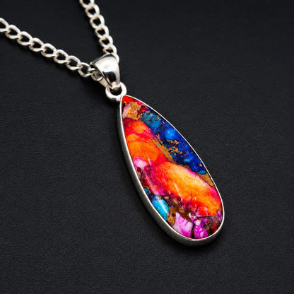 Close-up view of orange, pink and turquoise stone inlay on teardrop pendant