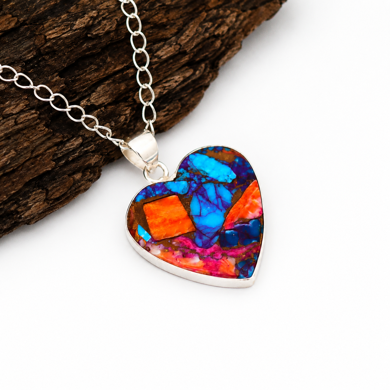 Copper turquoise heart pendant necklace displayed on wooden block